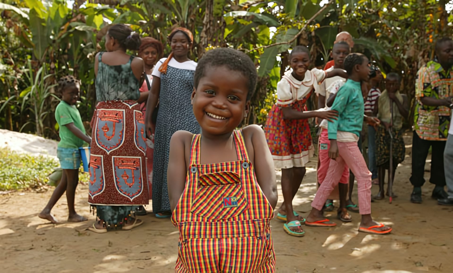 Enfants d'un village gabonais, une fillette souriante au premier plan, bénéficiaires des bourses de scolarisation Ebando