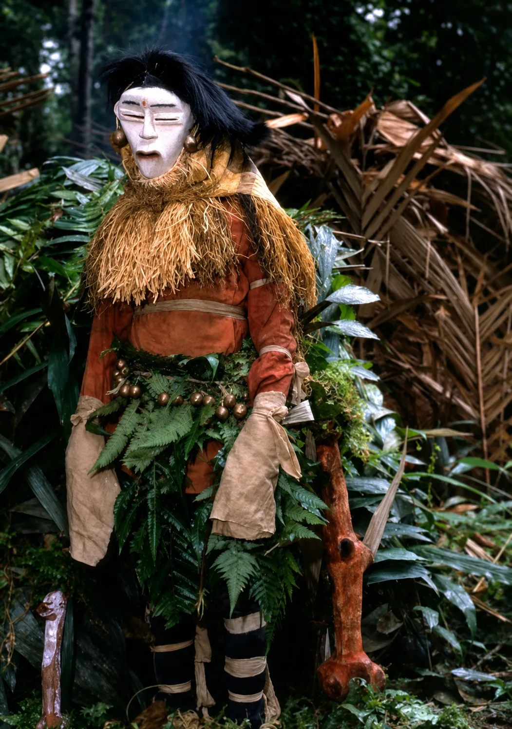 A dancer wearing a raffia mask in the forest — the living culture of the Bwiti
