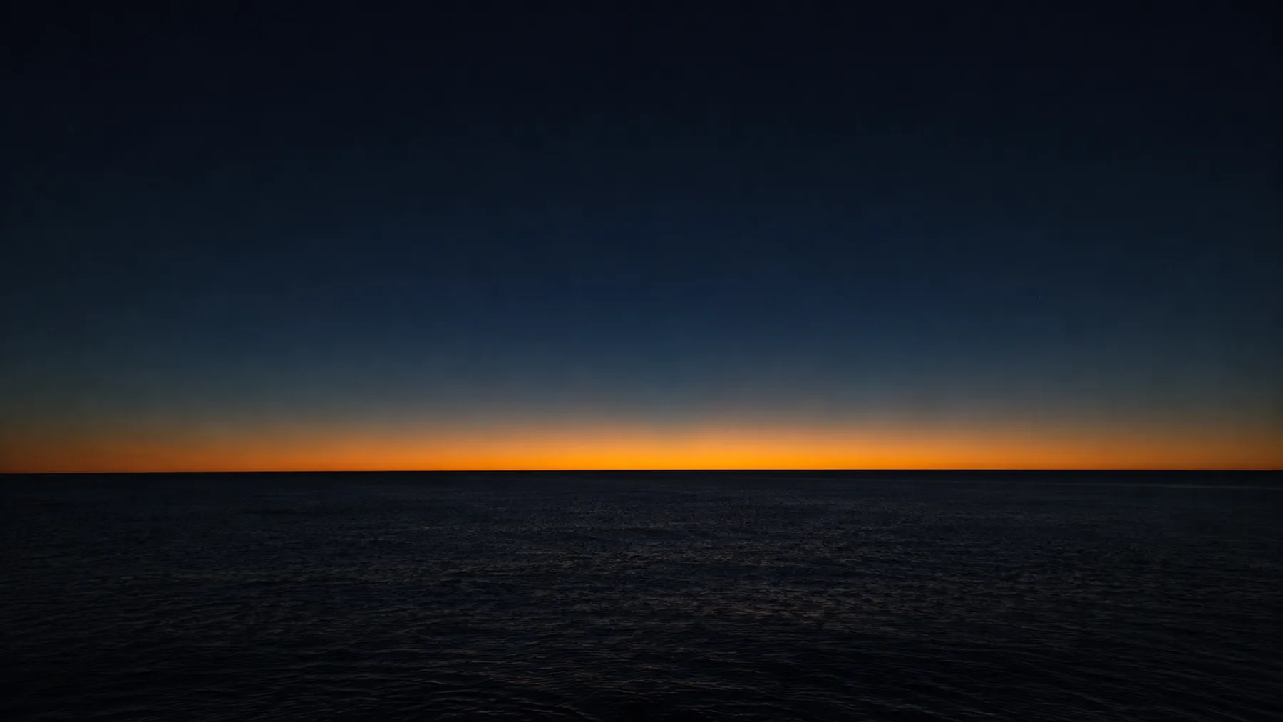 L'horizon à l'instant de l'aube, une ligne d'or entre la nuit et le jour : le seuil