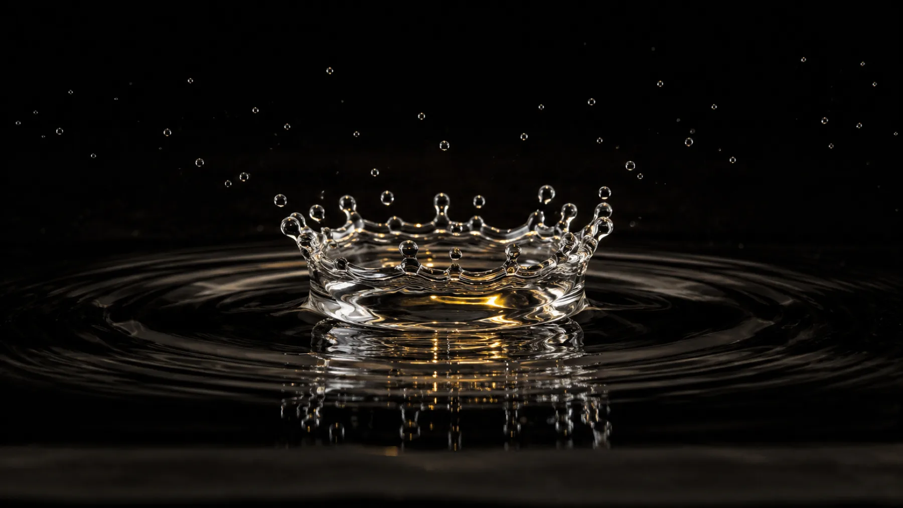 Une goutte d'eau à l'instant de l'impact, couronne et ondes concentriques : l'effet-miroir